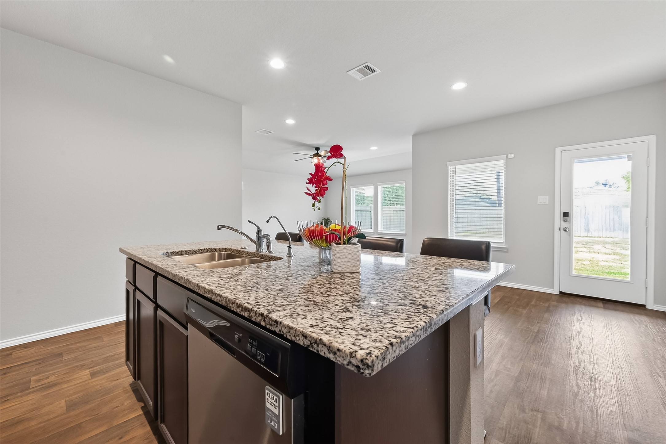 23511 Treeline Bluff Trail Spring Spring, TX 77373 - Photo 16 of 41 a very nice looking kitchen with granite countertop a sink dishwasher and a dining table with wooden floor