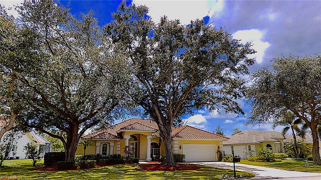a front view of a building with large trees