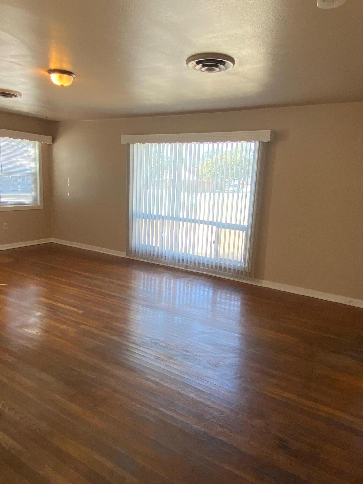 1410 Miller Way Red Bluff, CA 96080 - Photo 5 of 22 an empty room with wooden floor and windows