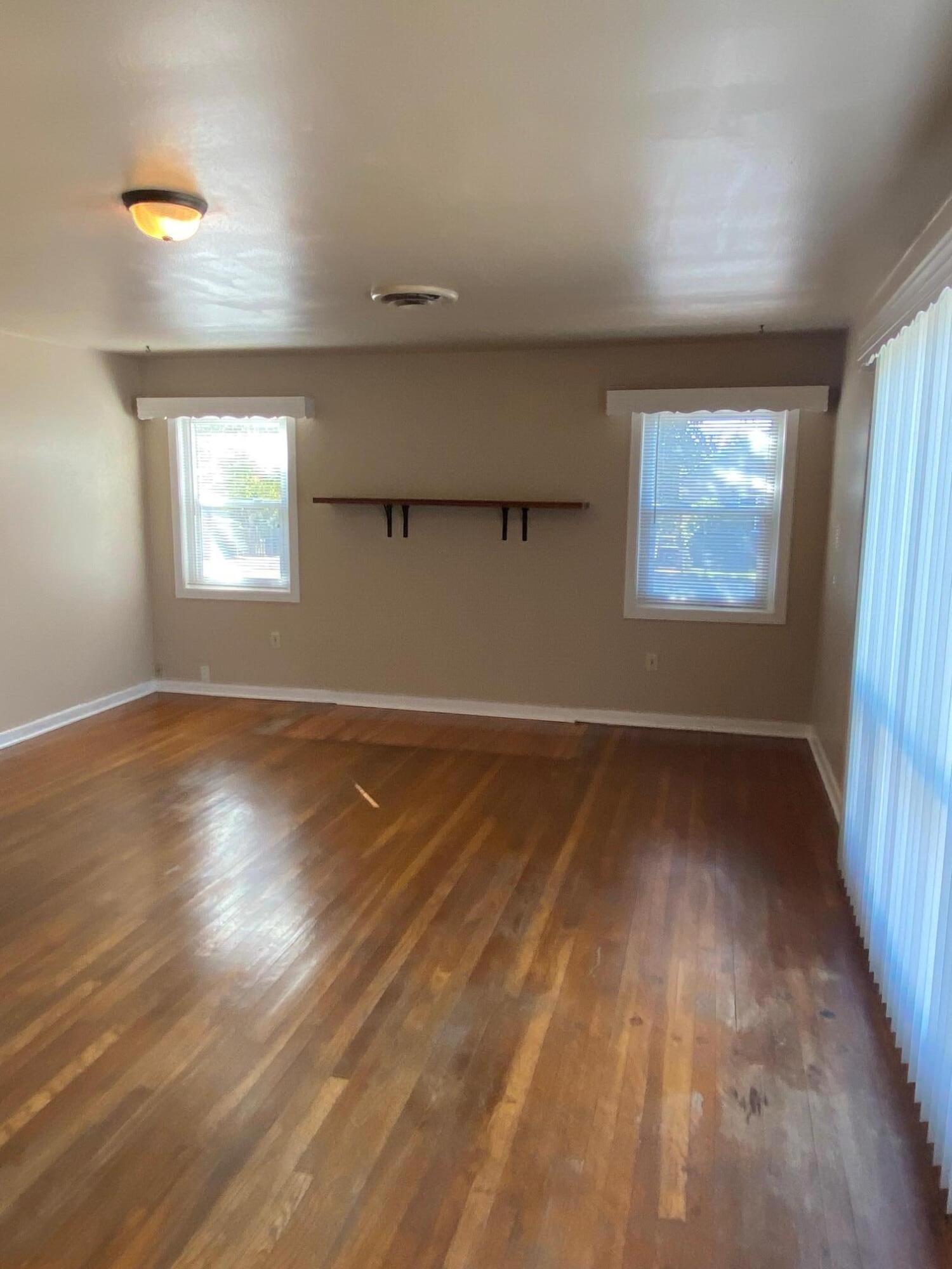 1410 Miller Way Red Bluff, CA 96080 - Photo 6 of 22 an empty room with wooden floor and windows