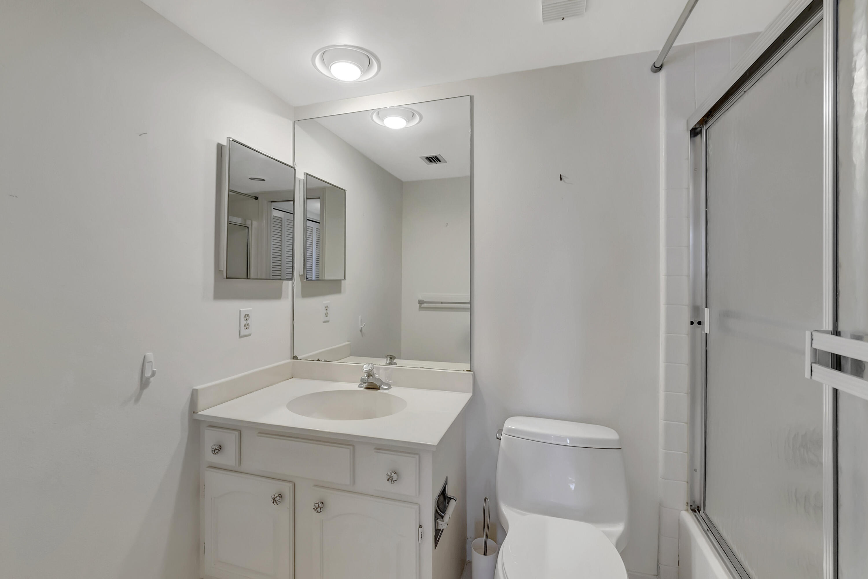 7738 Lakeside Boulevard, Unit 353 Boca Raton, FL 33434 - Photo 24 of 76 a bathroom with a toilet sink and mirror