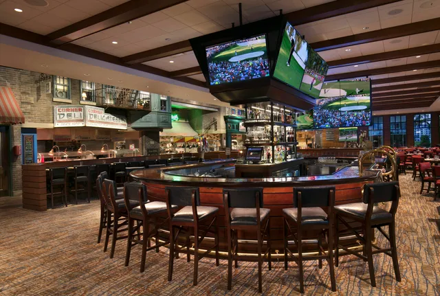 a kitchen with stainless steel appliances granite countertop a table chairs and a refrigerator