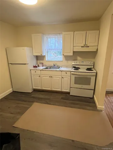 a kitchen with cabinets stove and white stainless steel appliances