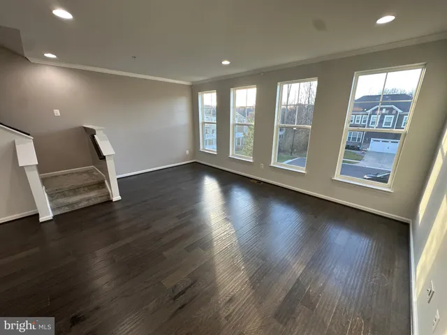 a view of room with wooden floor and windows