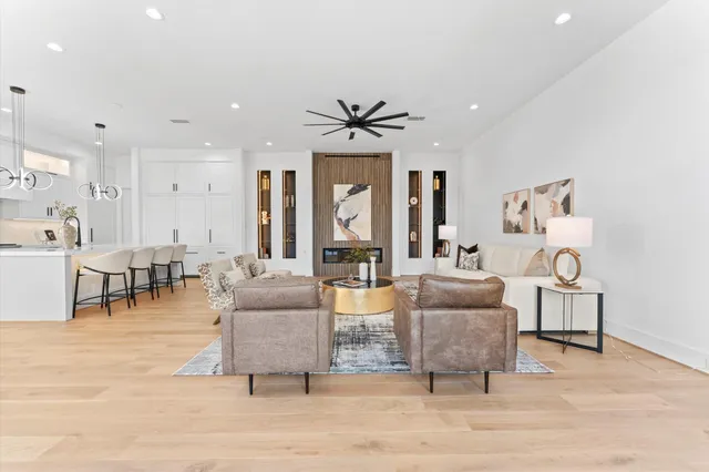 a large white kitchen with a large window a sink and stainless steel appliances