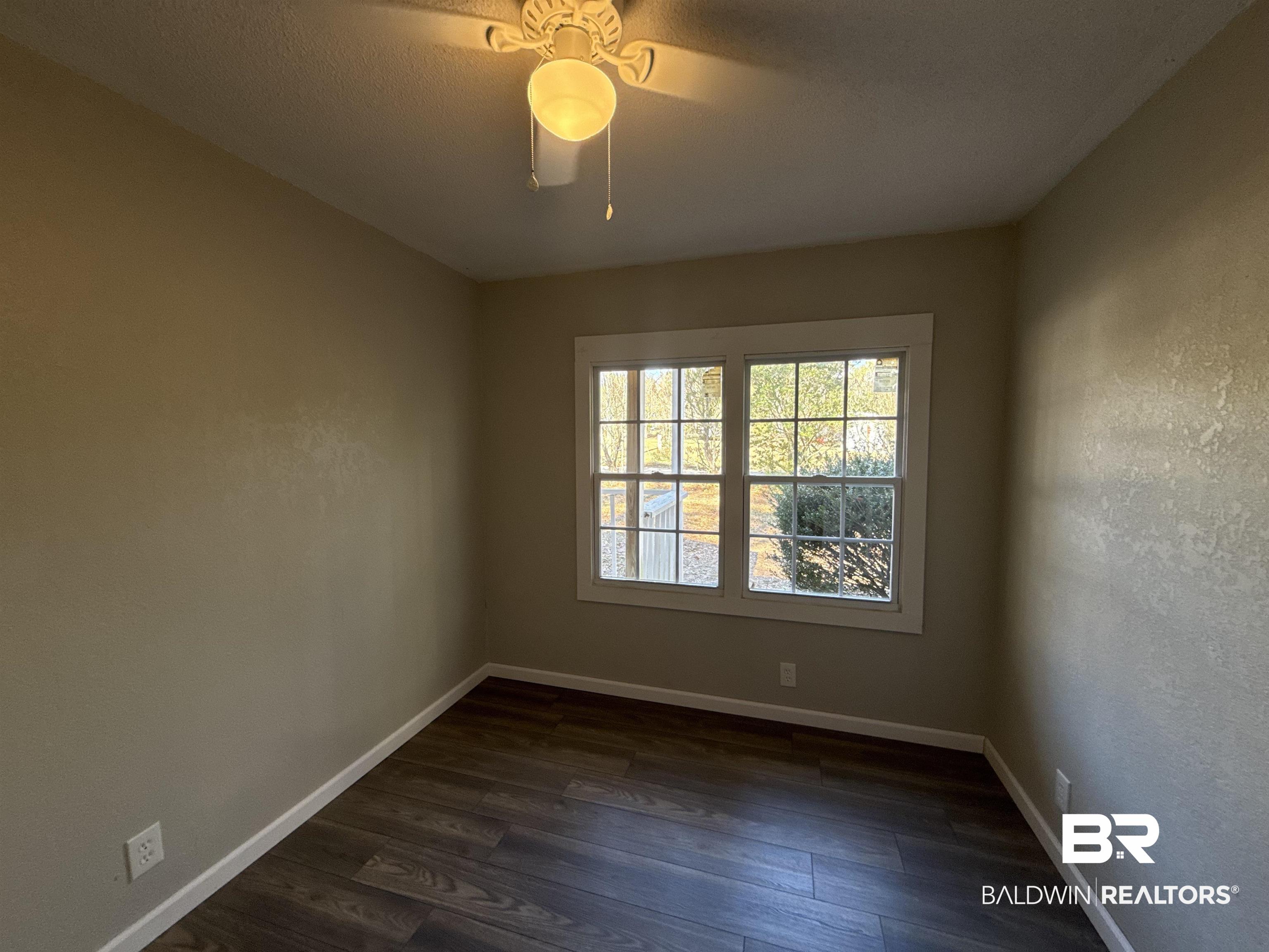 32 Slate Street Atmore, AL 36502 - Photo 10 of 16 Unfurnished room with dark wood-style flooring and baseboards