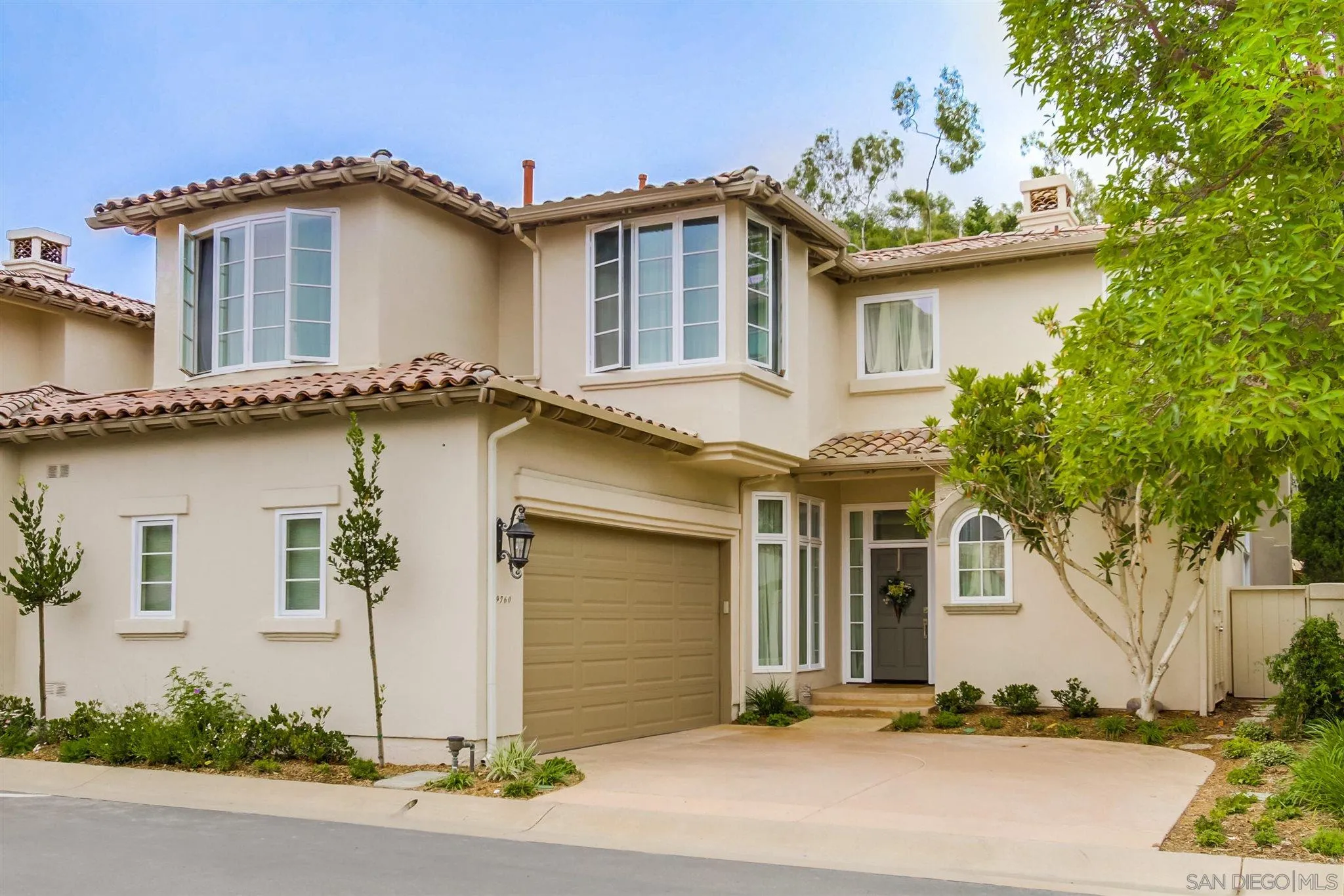 a white house that has a tree in front of it