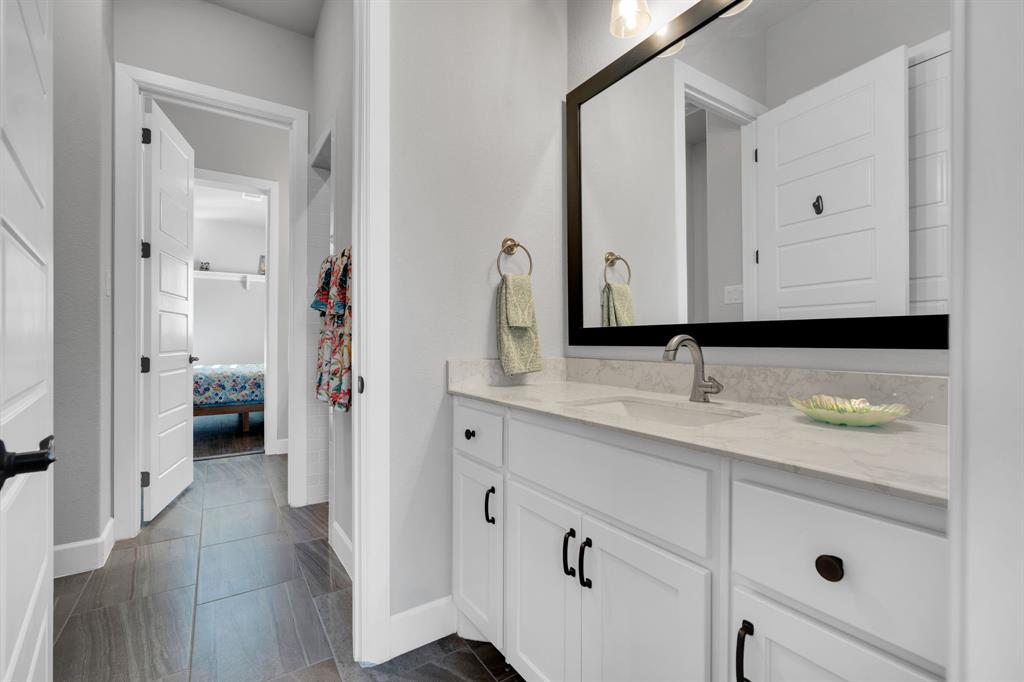 2501 Running Ranch Place Arlington, TX 76001 - Photo 27 of 38 a en suite bathroom with a granite countertop sink and a mirror