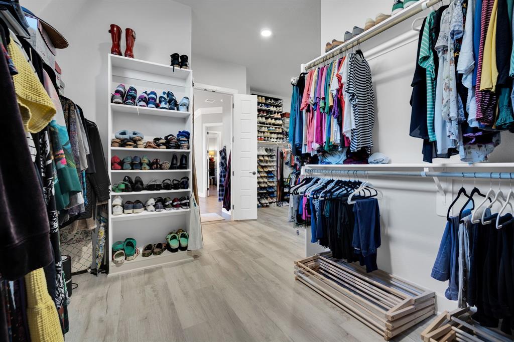 2501 Running Ranch Place Arlington, TX 76001 - Photo 34 of 38 a view of walk in closet with clothes and shoes