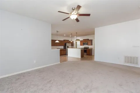 an empty room with closet and a chandelier fan