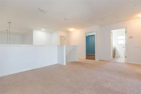 a view of an empty room with closet and a bathroom