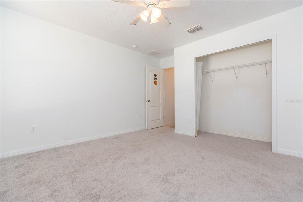 1803 Palm Warbler Lane Ruskin, FL 33570 - Photo 32 of 51 an empty room with a chandelier fan and closet area
