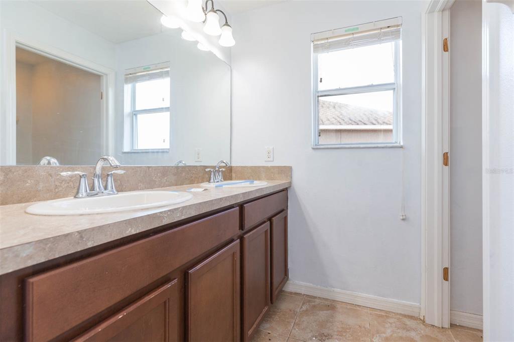 1803 Palm Warbler Lane Ruskin, FL 33570 - Photo 33 of 51 a bathroom with a granite countertop sink a large mirror and a window
