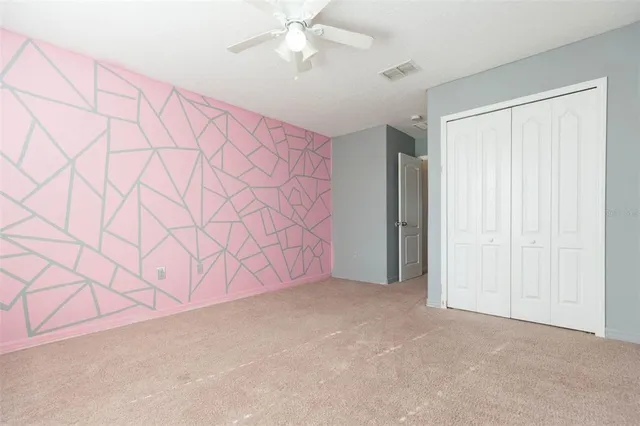 an empty room with a window and a chandelier fan