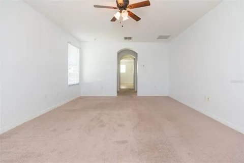 an empty room with a window and a ceiling fan