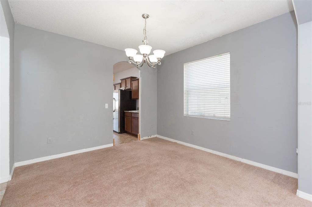 1803 Palm Warbler Lane Ruskin, FL 33570 - Photo 8 of 51 an empty room with chandelier fan and windows