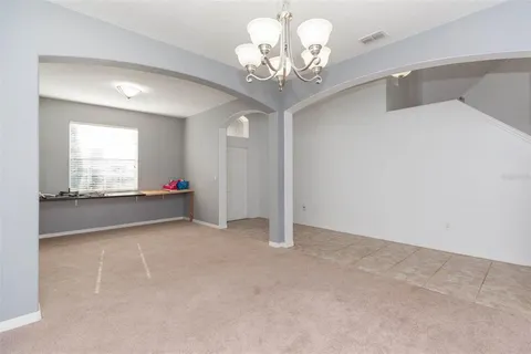 a view of a hallway with windows and chandelier