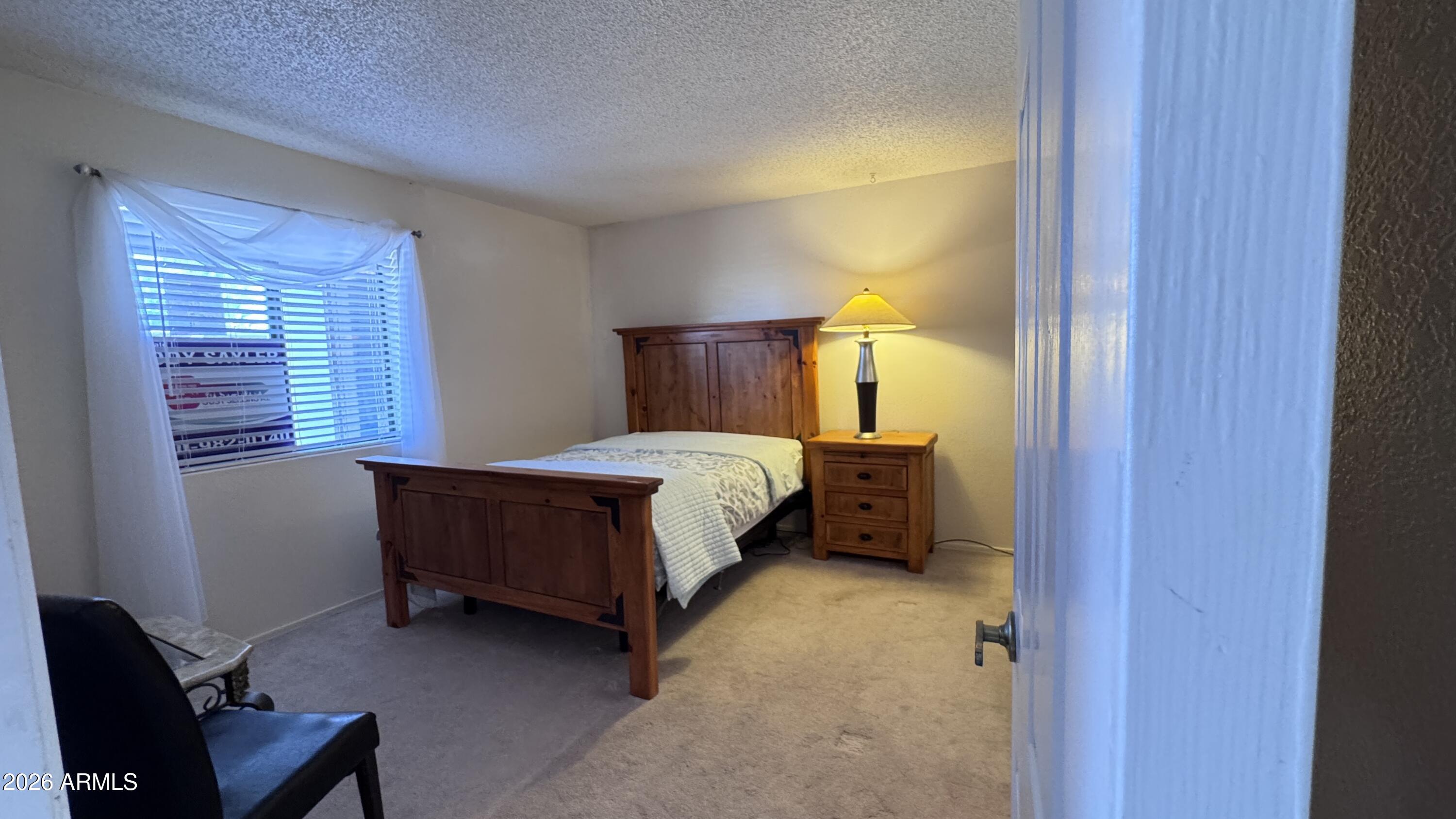 1440 North Idaho Road, Unit 1016 Apache Junction, AZ 85119 - Photo 11 of 22 a bedroom with a bed and a window