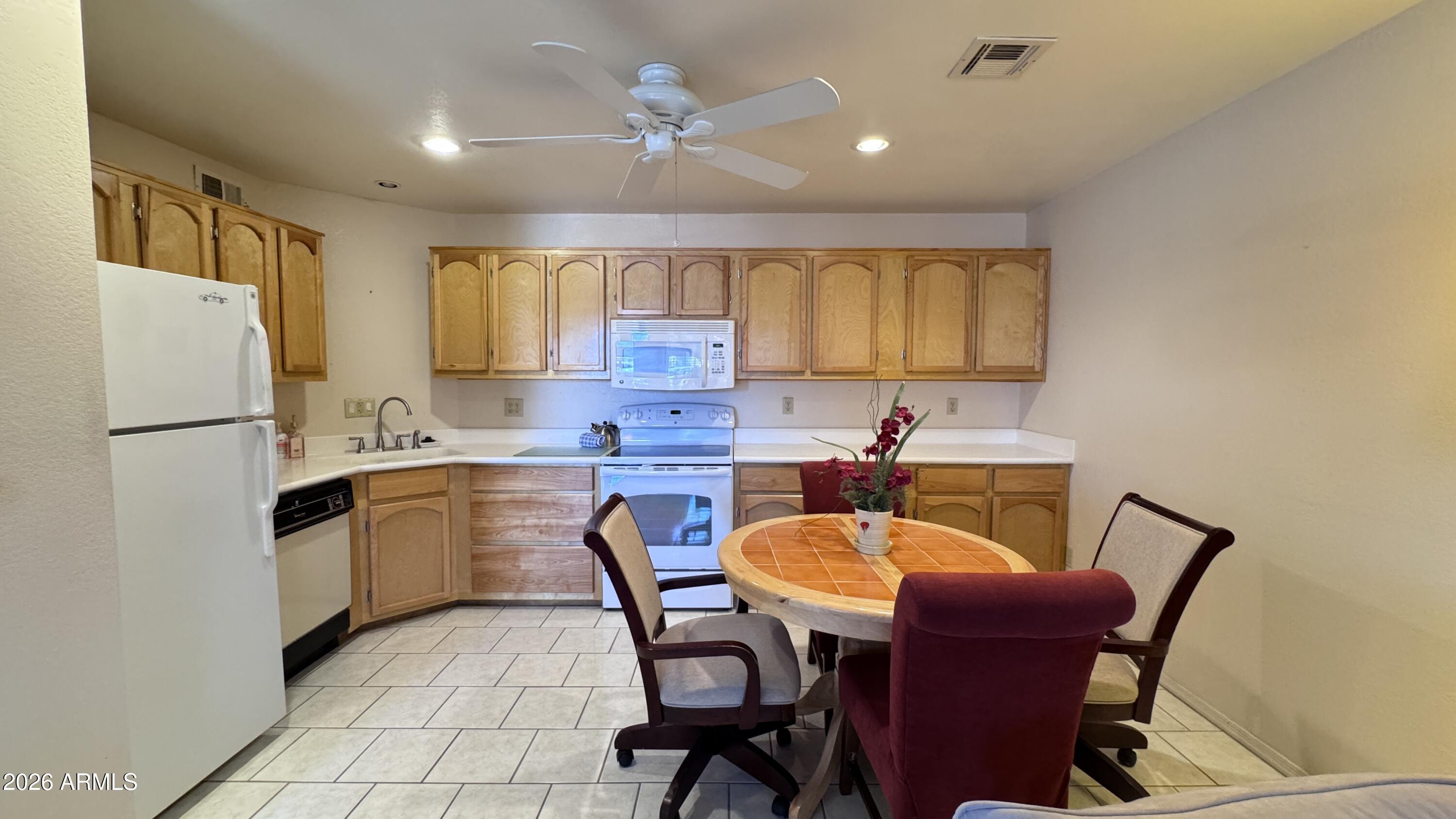1440 North Idaho Road, Unit 1016 Apache Junction, AZ 85119 - Photo 8 of 22 a kitchen with stainless steel appliances granite countertop a sink a stove a refrigerator with a dining table and chairs