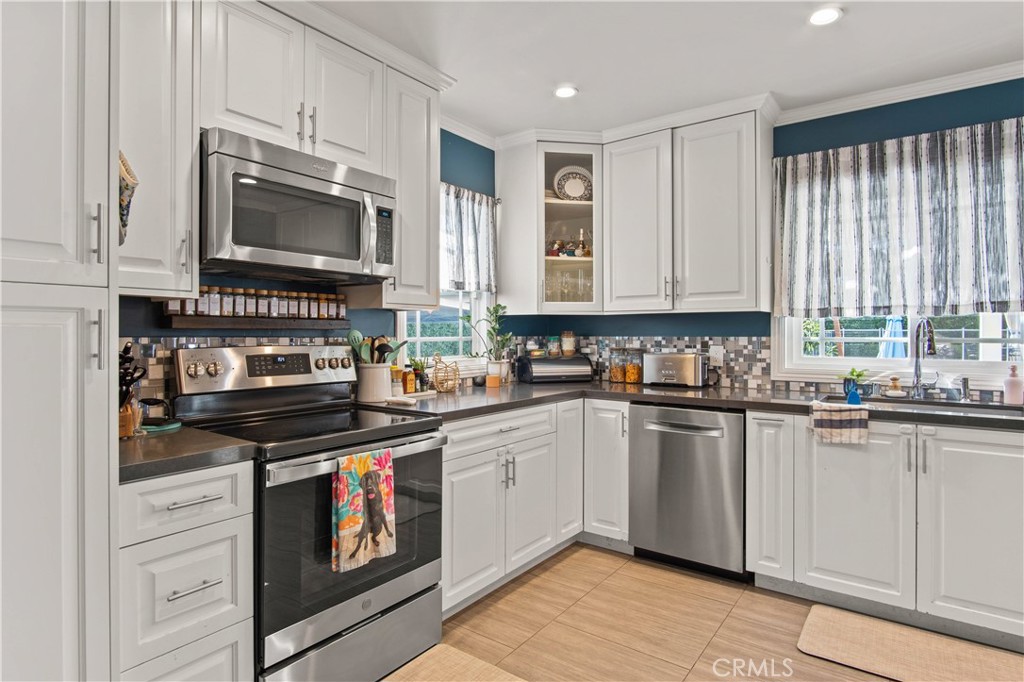 6835 Aldea Avenue Van Nuys, CA 91406 - Photo 7 of 50 a kitchen with granite countertop a stove top oven microwave and cabinets