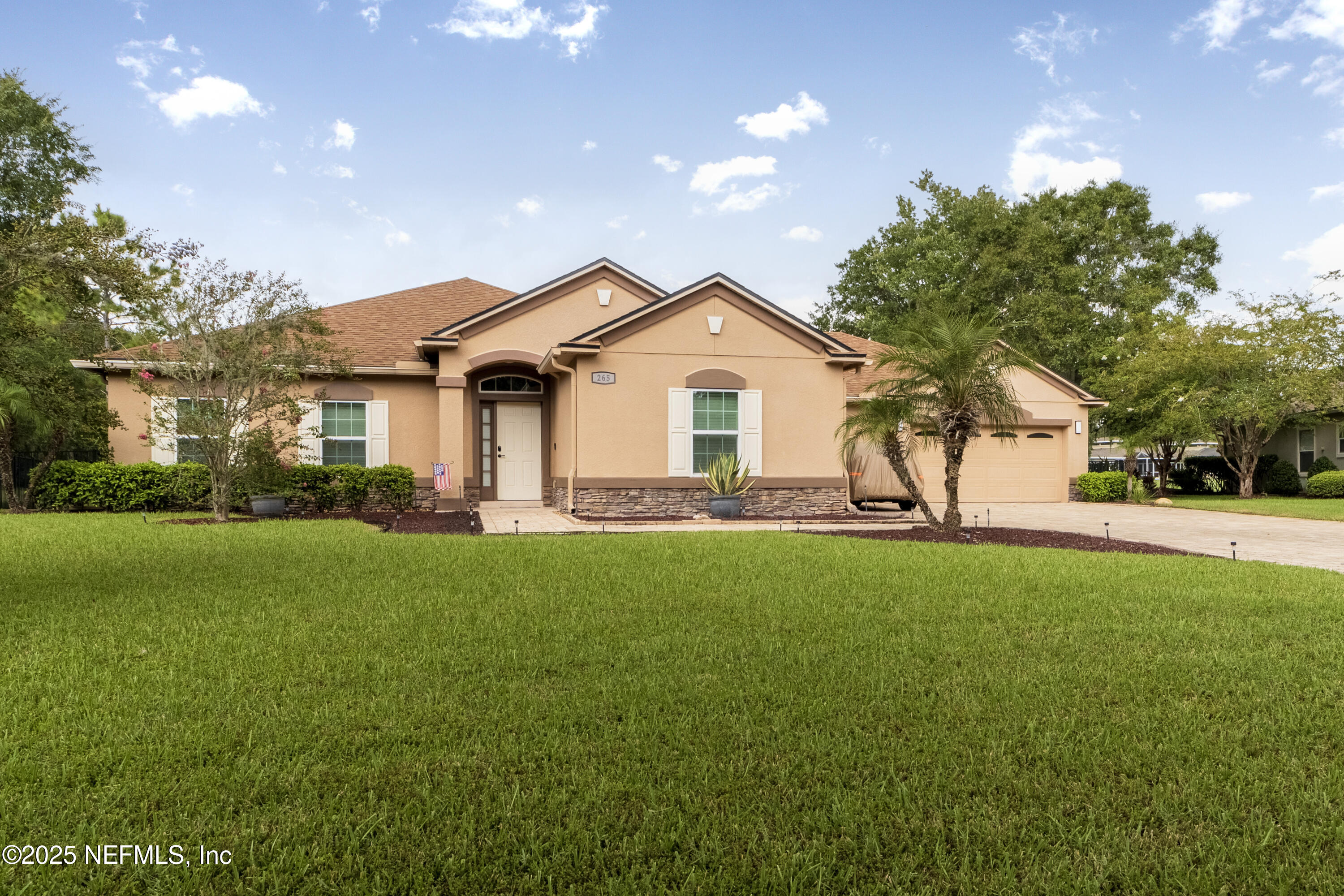 a front view of a house with a garden and yard