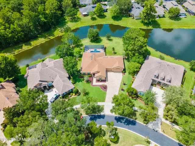 an aerial view of a house with a garden and lake view