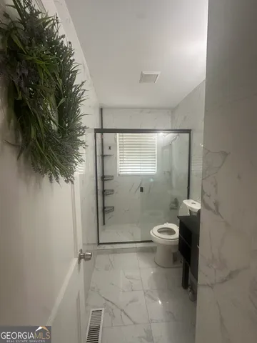 a bathroom with a toilet a sink and shower