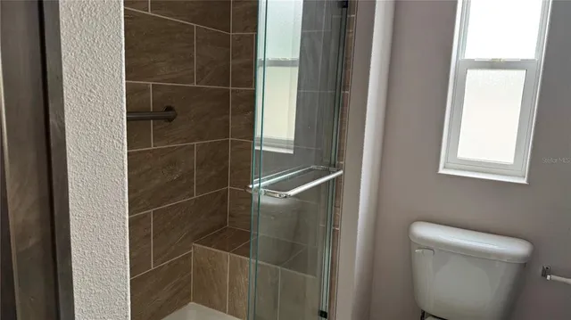 a bathroom with a toilet and a shower