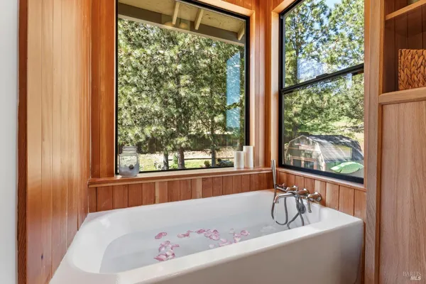 a bathroom with a bathtub and windows