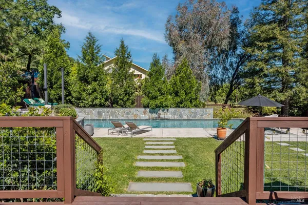 a view of a swimming pool with a patio and a yard
