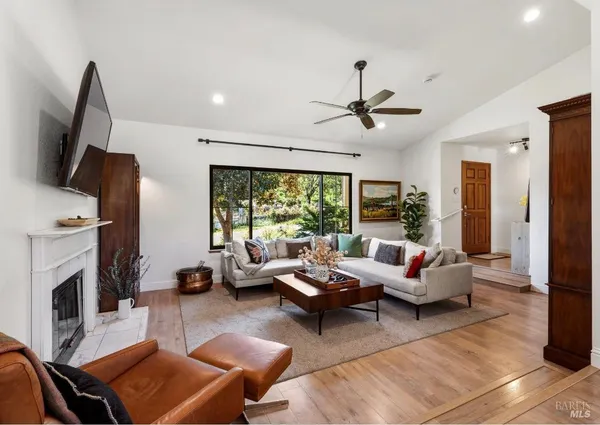 a living room with furniture fireplace and a large window