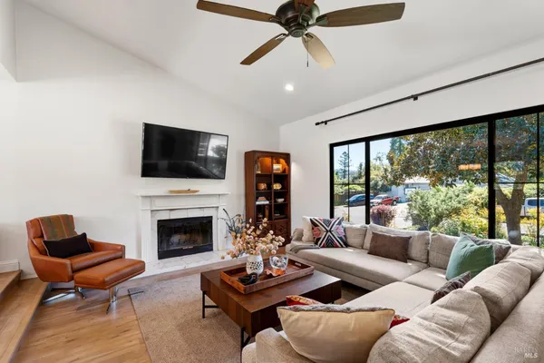 a living room with furniture fireplace and a large window