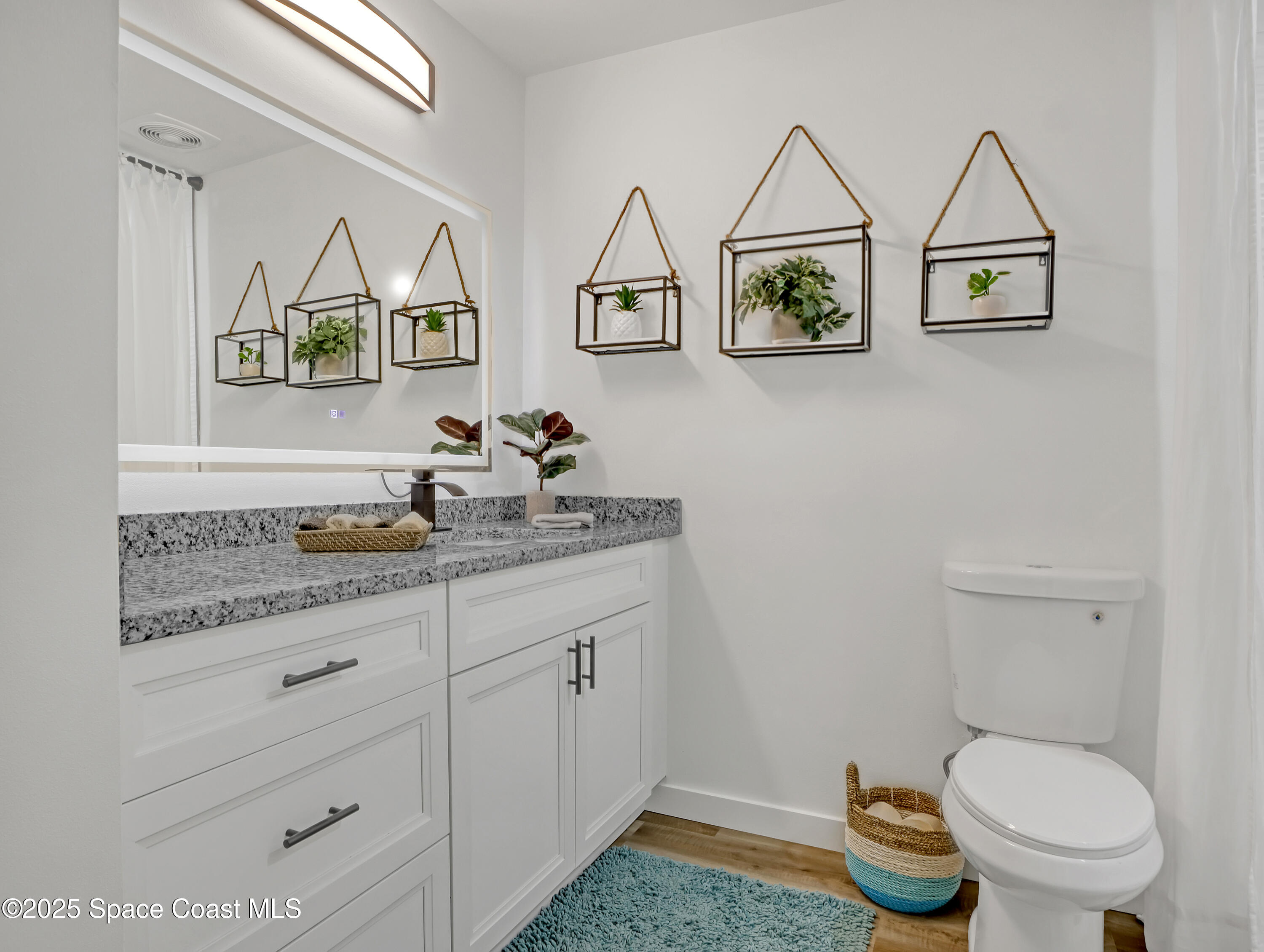 872 Sadnet Circle Northeast Palm Bay, FL 32905 - Photo 13 of 21 a bathroom with a granite countertop toilet and a sink