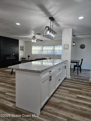 a bathroom with a granite countertop sink a toilet a mirror and bathtub