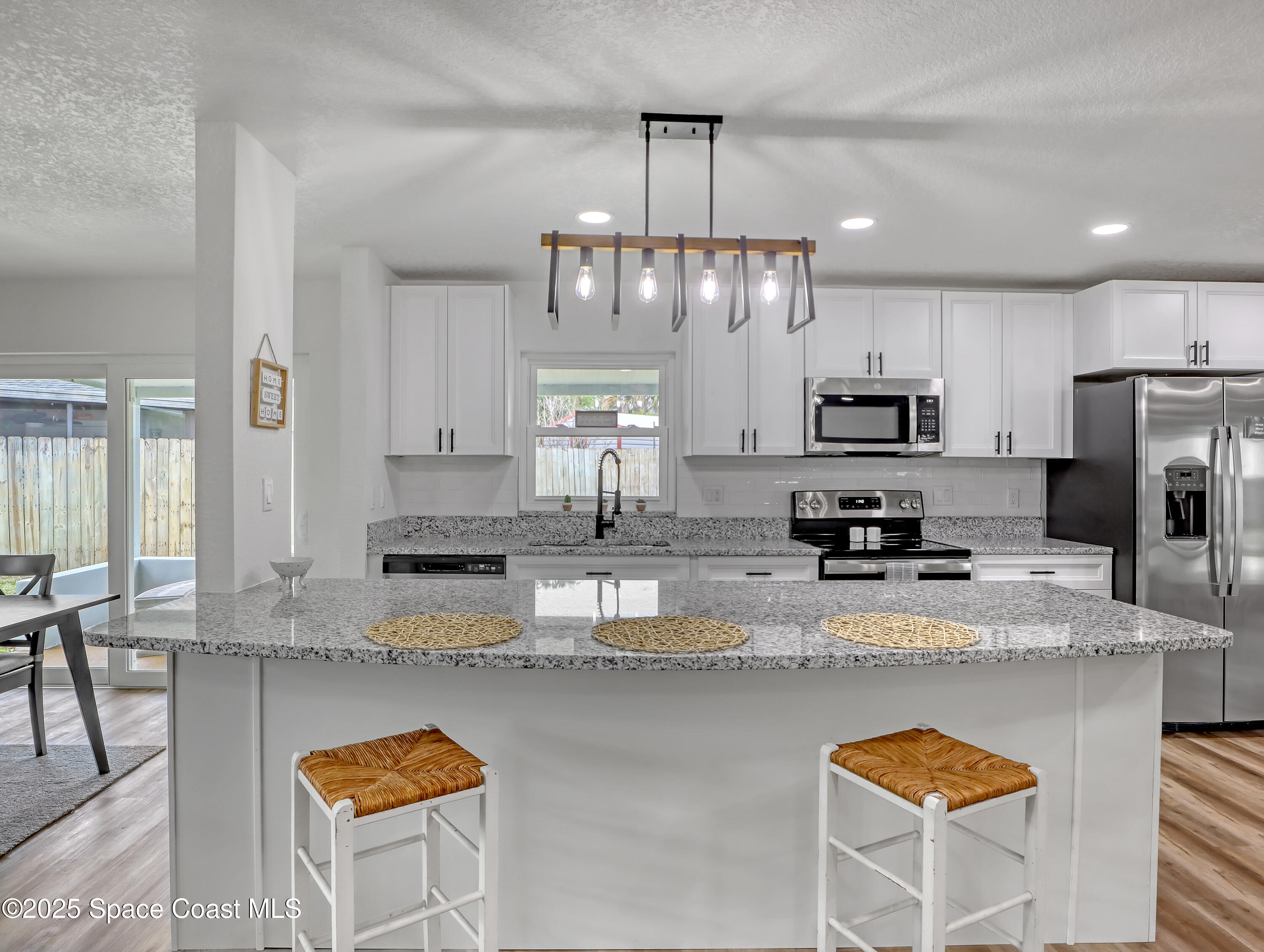 872 Sadnet Circle Northeast Palm Bay, FL 32905 - Photo 2 of 21 a kitchen with stainless steel appliances granite countertop a sink refrigerator stove and microwave