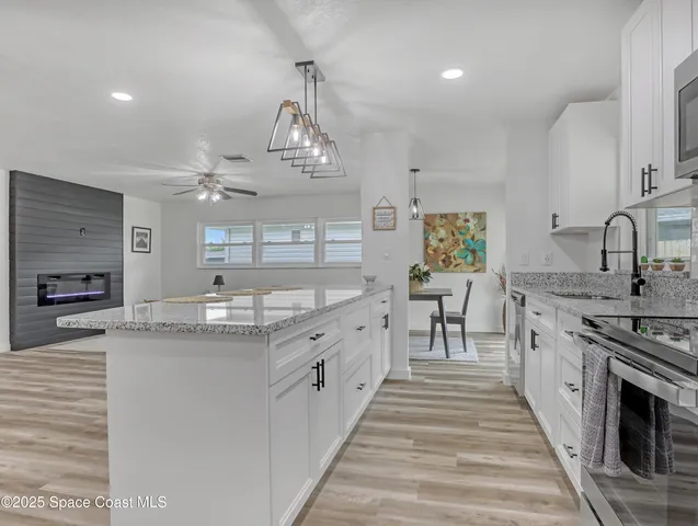 a large kitchen with stainless steel appliances granite countertop a sink and stove