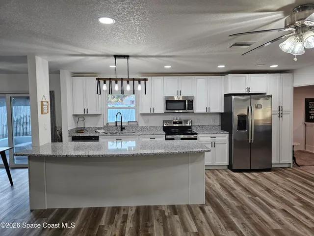 a living room with furniture a ceiling fan and a rug