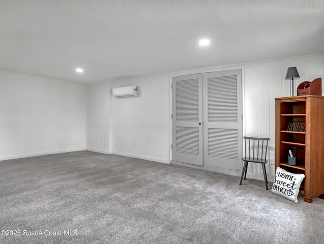 a view of an empty room with cabinet and mirrors