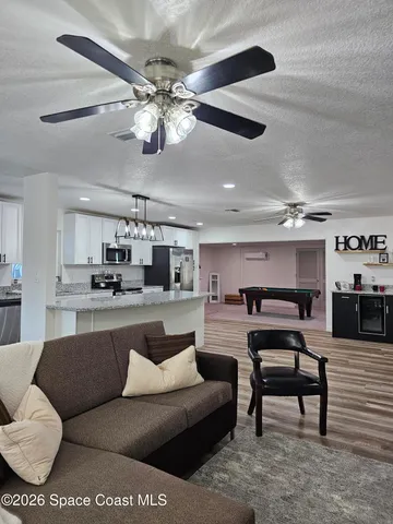 a large kitchen with stainless steel appliances granite countertop a lot of counter space and wooden floor