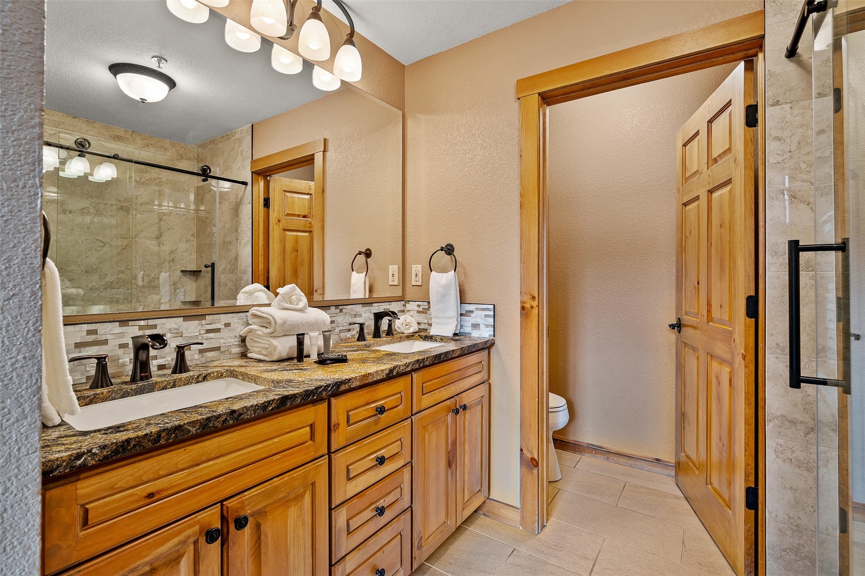 57 Lake Ridge Circle, Unit 1848 Keystone, CO 80435 - Photo 21 of 49 a bathroom with a granite countertop sink mirror and a shower