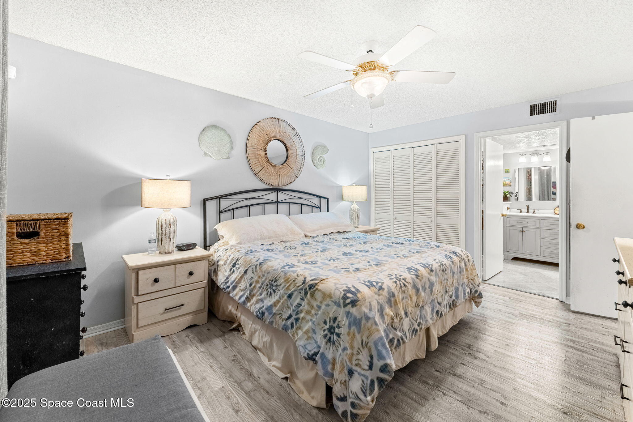 6205 Treetop Drive Melbourne Beach, FL 32951 - Photo 11 of 36 a bedroom with a bed and wooden floor