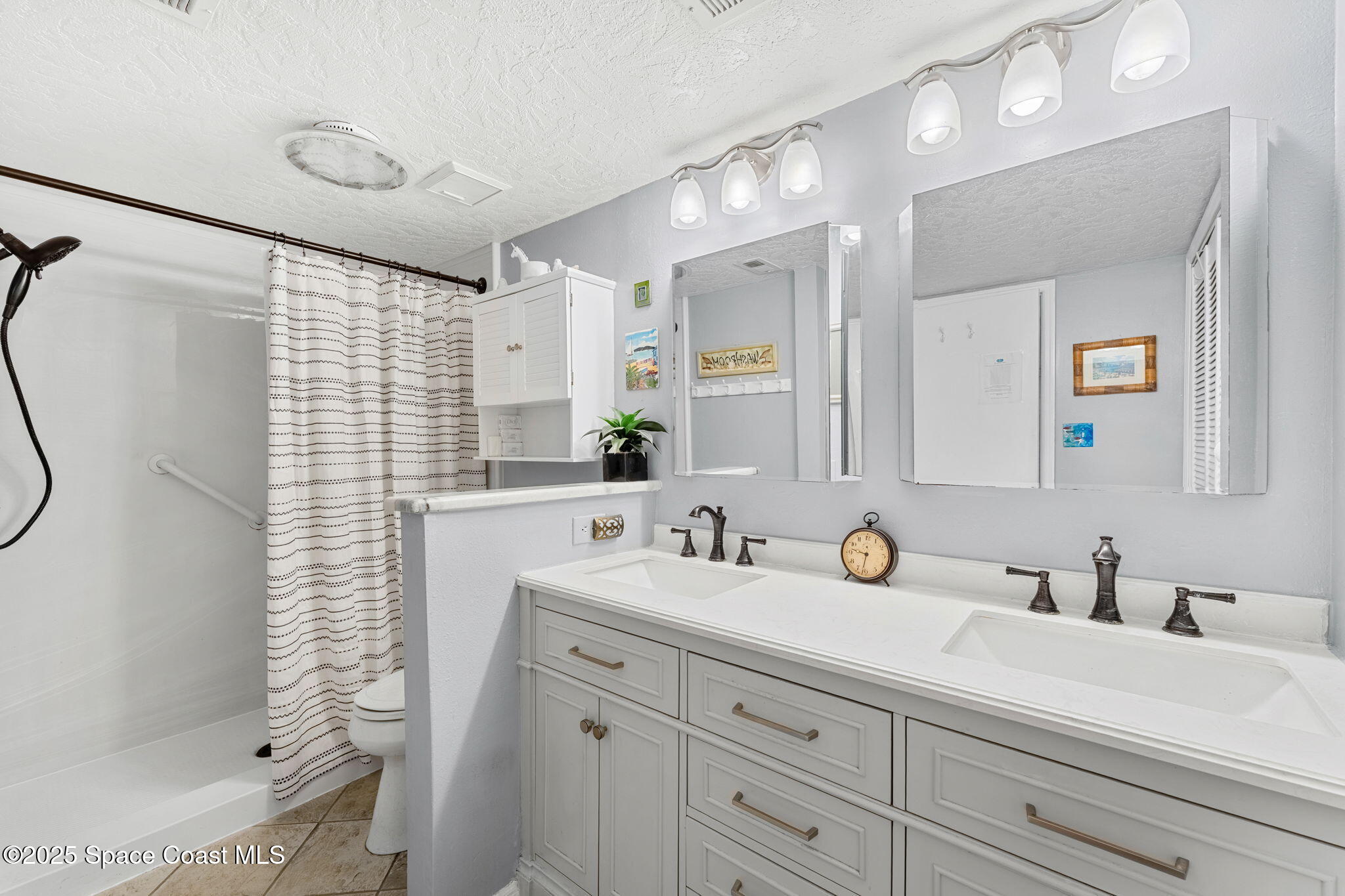 6205 Treetop Drive Melbourne Beach, FL 32951 - Photo 13 of 36 a bathroom with a sink double vanity and shower