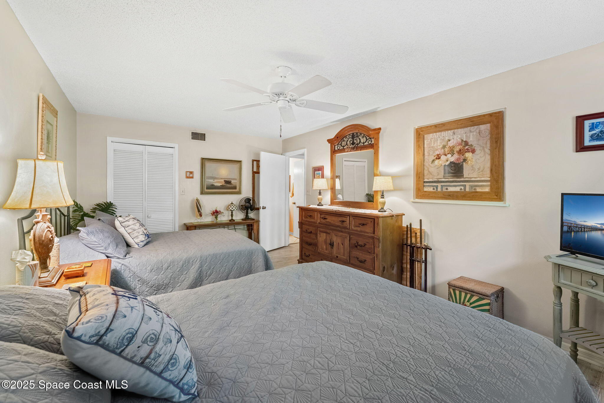 6205 Treetop Drive Melbourne Beach, FL 32951 - Photo 15 of 36 a bedroom with a bed and a flat screen tv