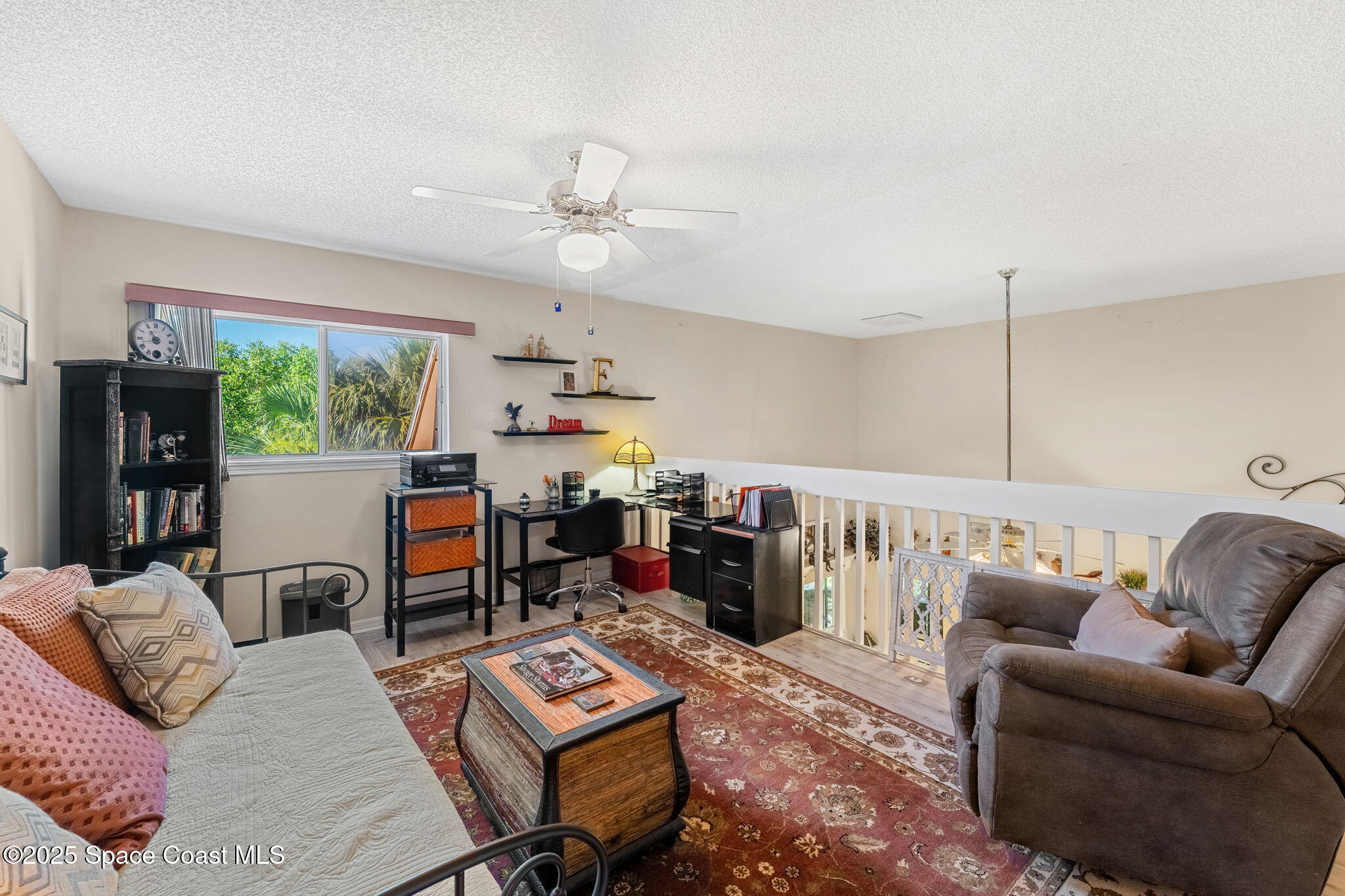 6205 Treetop Drive Melbourne Beach, FL 32951 - Photo 17 of 36 a living room with furniture a flat screen tv and a large window