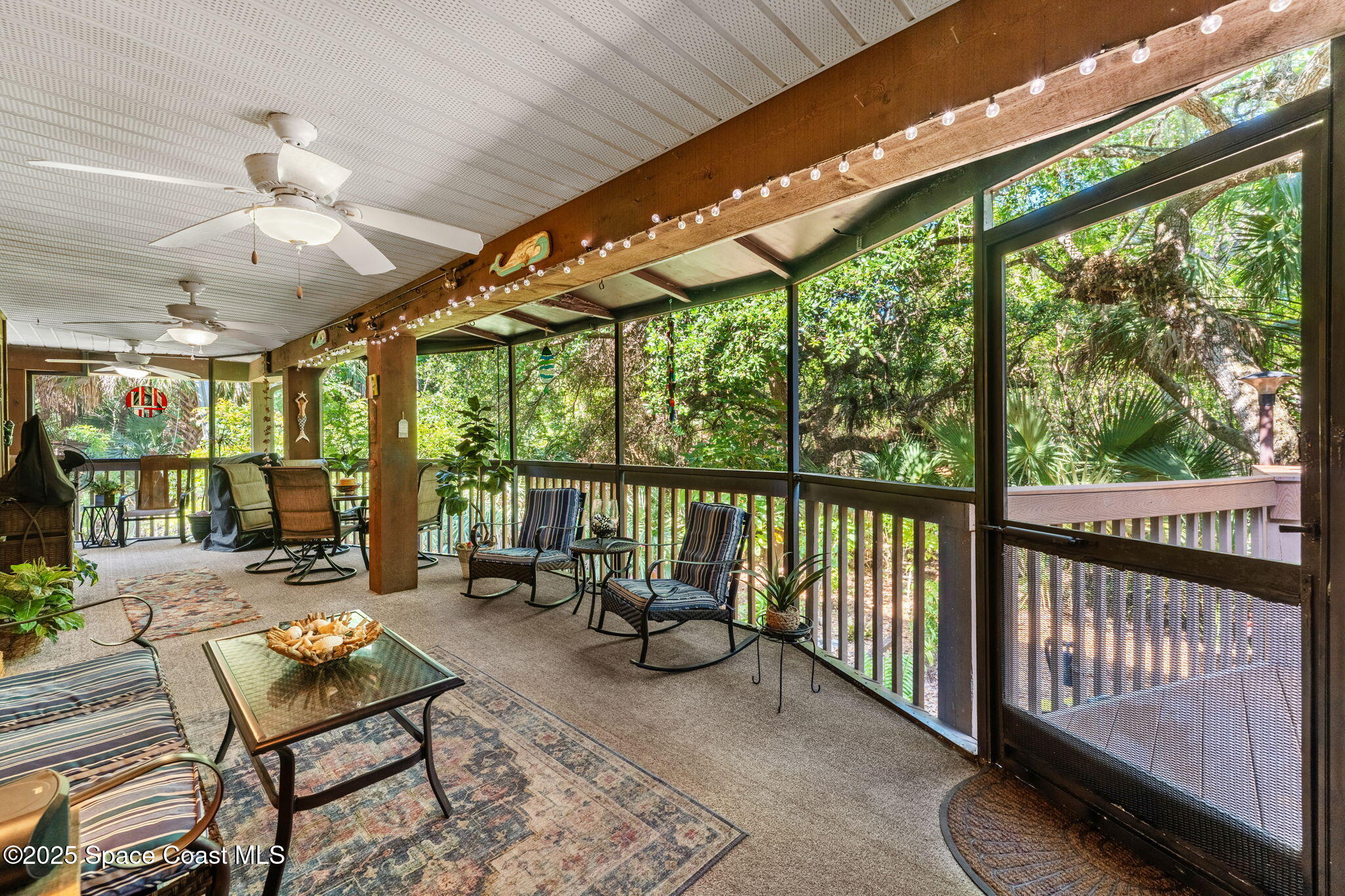 6205 Treetop Drive Melbourne Beach, FL 32951 - Photo 2 of 36 a living room with furniture and a floor to ceiling window