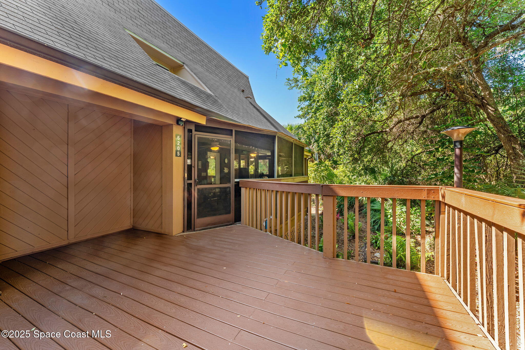 6205 Treetop Drive Melbourne Beach, FL 32951 - Photo 25 of 36 a view of a balcony with wooden floor and fence