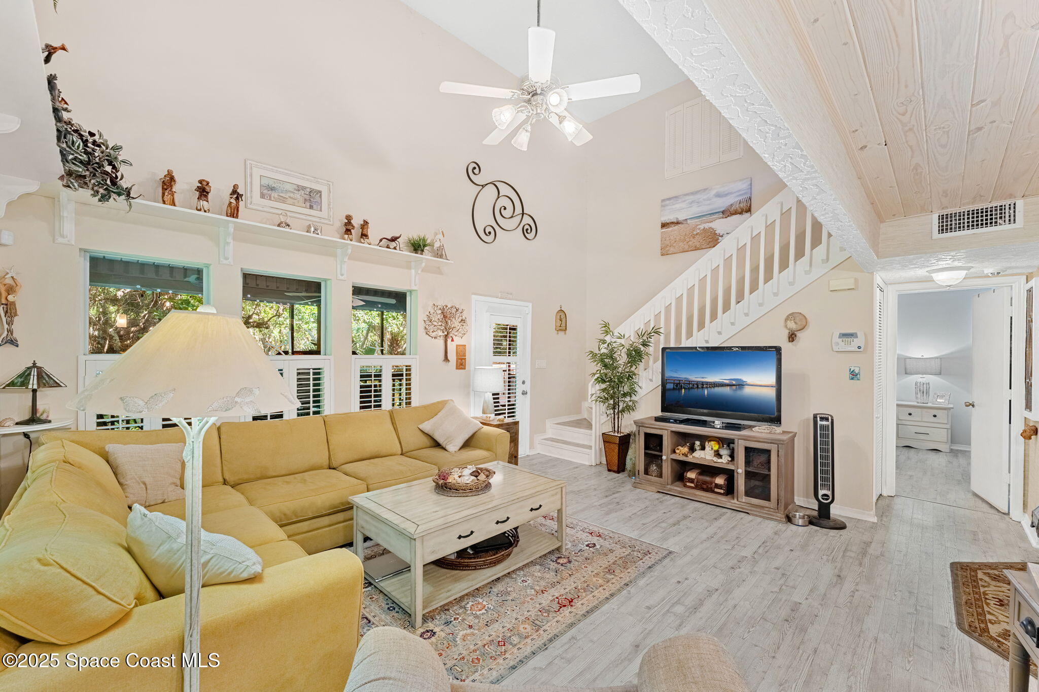 6205 Treetop Drive Melbourne Beach, FL 32951 - Photo 5 of 36 a living room with furniture a flat screen tv and kitchen view
