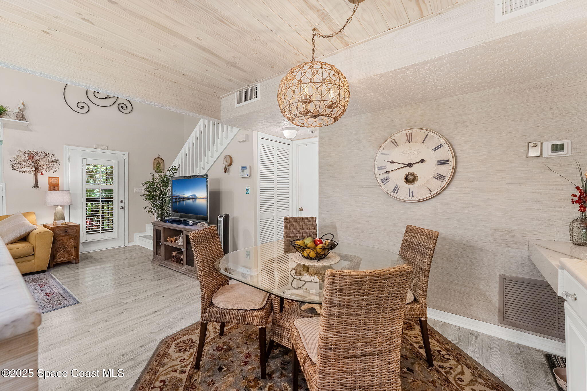6205 Treetop Drive Melbourne Beach, FL 32951 - Photo 9 of 36 a view of a dining room with furniture wooden floor and a clock