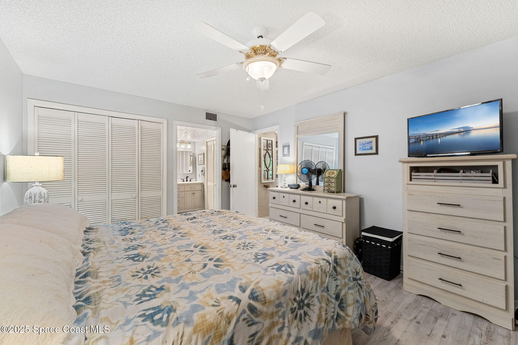 6205 Treetop Drive Melbourne Beach, FL 32951 - Photo 10 of 36 a large bedroom with a bed and a flat screen tv