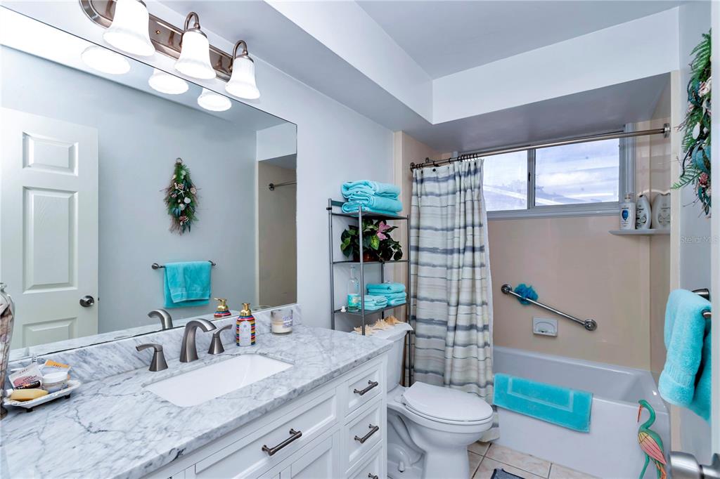 10901 Southwest 80th Court Ocala, FL 34481 - Photo 21 of 46 a bathroom with a granite countertop sink a toilet a mirror and shower